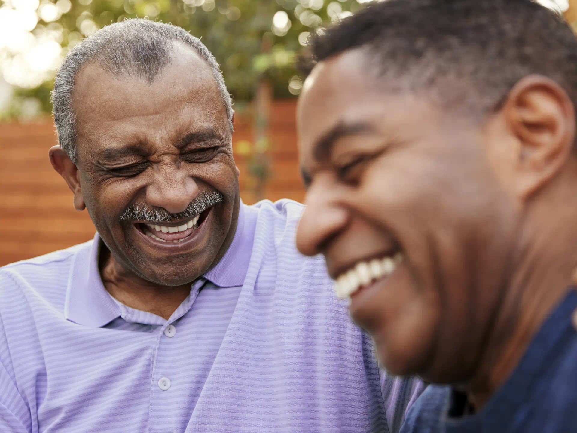 Father and son having a good time while wearing hearing aids